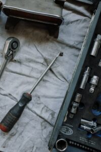 Close-up of automotive tools and toolbox in a repair workshop setting.