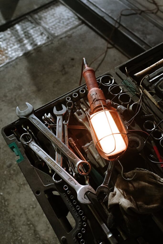 A detailed view of a workshop setup with various tools and a glowing industrial lamp.